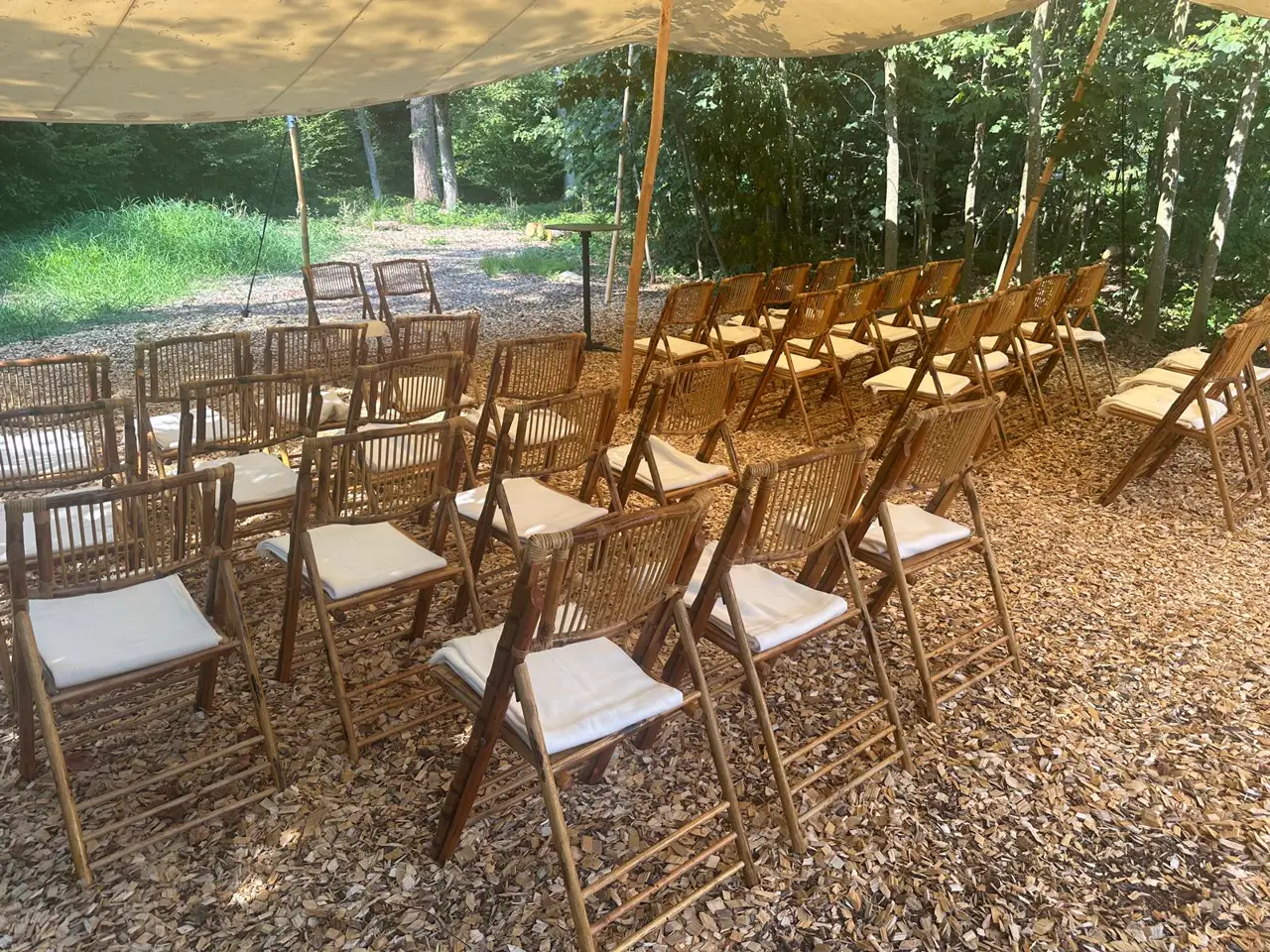 Bamboo folding chairs under the tent canopy in the forest