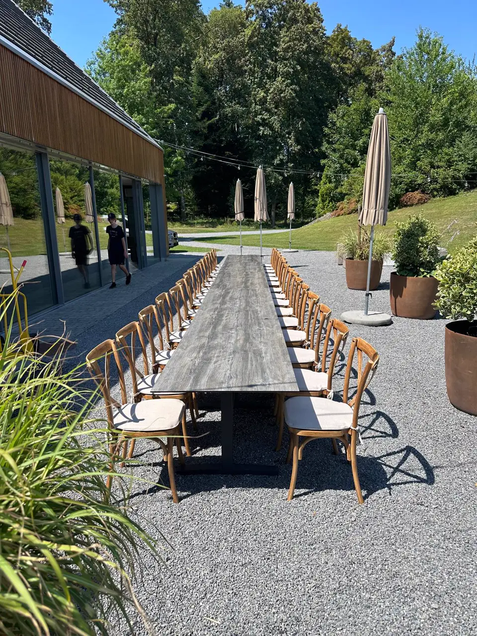 Wooden crossback chairs at the long banquet table in front of the Heuboden